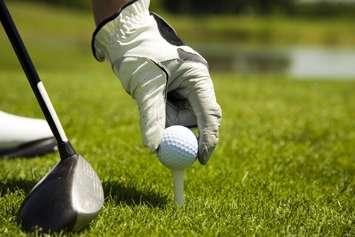 Golf club: golfer arranging the ball on the tee. © Can Stock Photo / diego_cervo